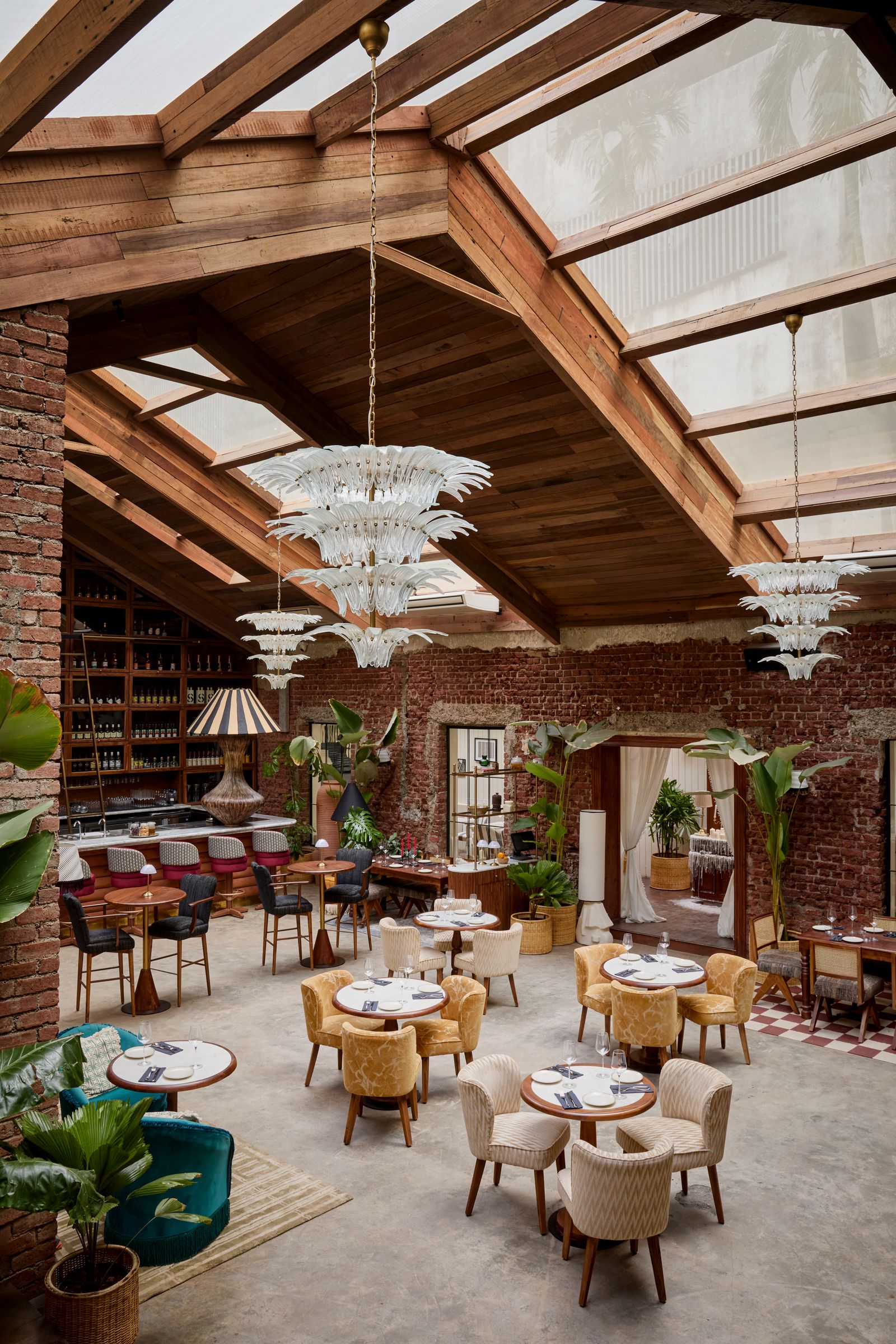 Image may contain Architecture Building Dining Room Dining Table Furniture Indoors Room Table Lamp Plant and Chair